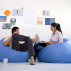 Businesspeople sitting in bean bag chairs and talking