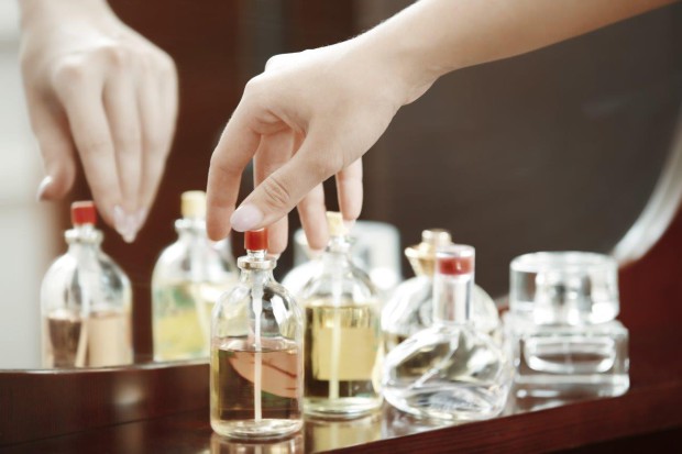 Woman Reaching for a Bottle of Perfume