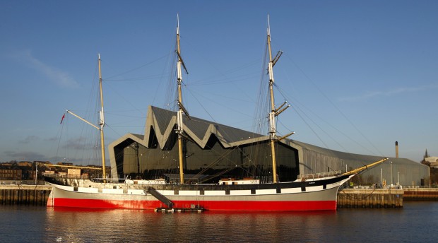 Large Boat in Water Next to a Large Modern Building