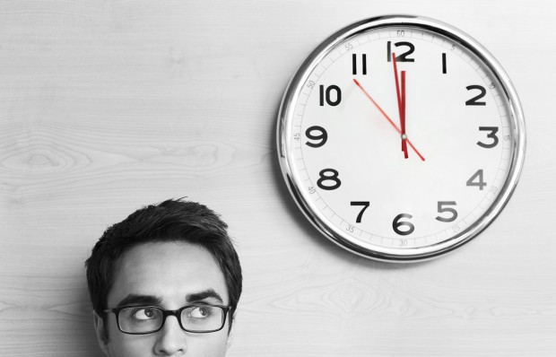 Man Stood Next to Clock in Black and White