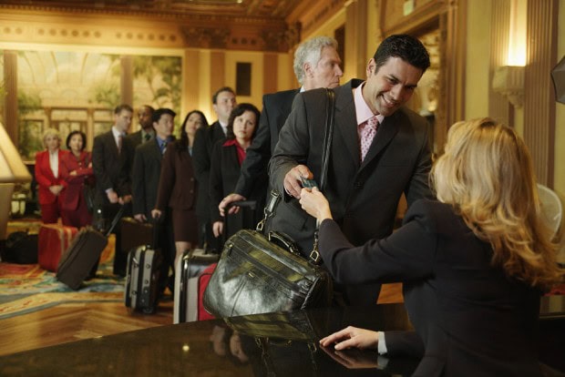 Line of Business men and Women Waiting to Check into a Hotel