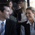 Businessman smiling at woman on bus