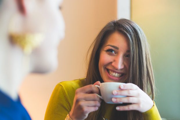 Two Women in a Cafe Smiling and Looking Each Other