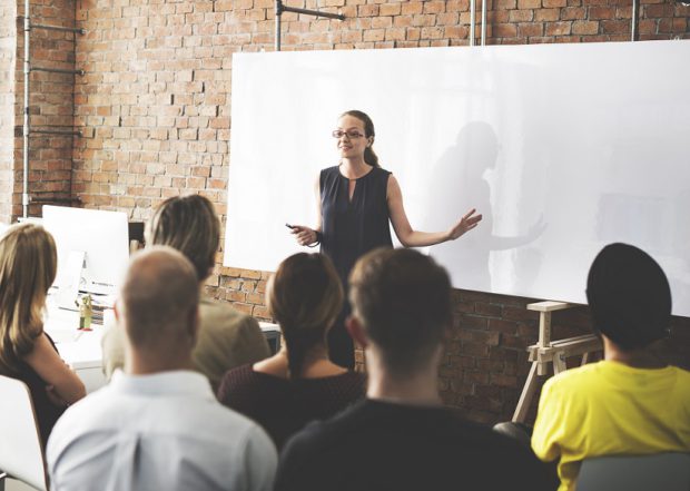 Woman Presenting in Front of a Whiteboard